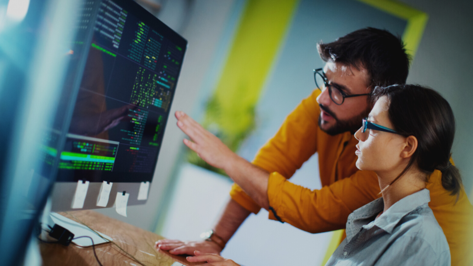 Foto van 2 mensen die werken aan code